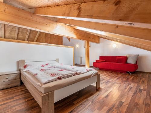 a bedroom with a bed and a red couch at Apartment Rot by Interhome in Lend