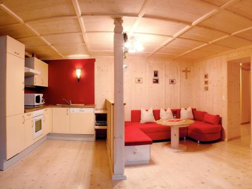 ein Wohnzimmer mit einem roten Sofa und einem Tisch in der Unterkunft Apartment Christoph by Interhome in Stumm
