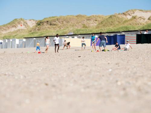 a group of people playing soccer on the beach at Apartment Appartement 64-202 by Interhome in Bredene