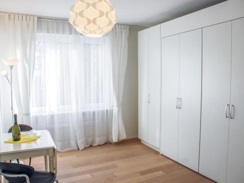 a kitchen with white cabinets and a table and a window at Apartment Residenza Corallo-16 by Interhome in Ascona