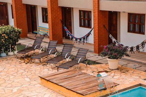 a group of chairs sitting next to a swimming pool at Pousada e Chale Porto Paraiso in Porto Seguro