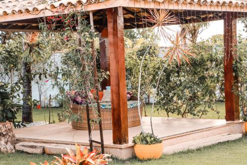 a wooden gazebo with potted plants on it at Pousada e Chale Porto Paraiso in Porto Seguro