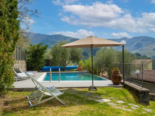 a swimming pool with an umbrella and two lawn chairs and an umbrella at Holiday Home Capanna by Interhome in San Clemente in Valle