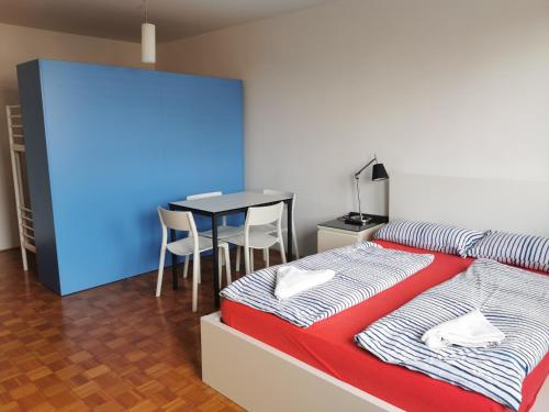 リュブリャナにあるDunajska Apartmentのベッドルーム1室(ベッド1台、テーブル、椅子付)