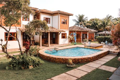 a house with a swimming pool in the yard at Pousada e Chale Porto Paraiso in Porto Seguro