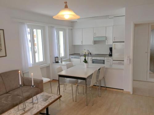 een keuken en een woonkamer met een tafel en een bank bij Apartment Val Signina-2 by Interhome in Laax-Murschetg