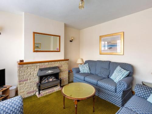 a living room with a couch and a fireplace at Holiday Home Trappers End by Interhome in Whitstable