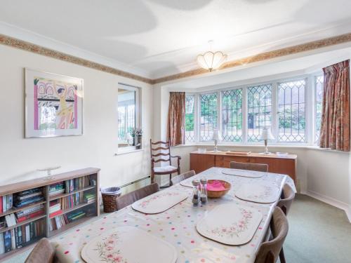 a dining room with a table and chairs and windows at Holiday Home Jeanettes by Interhome in New Malden