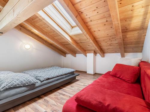 a bedroom with a bed and a red couch at Apartment Grün by Interhome in Lend