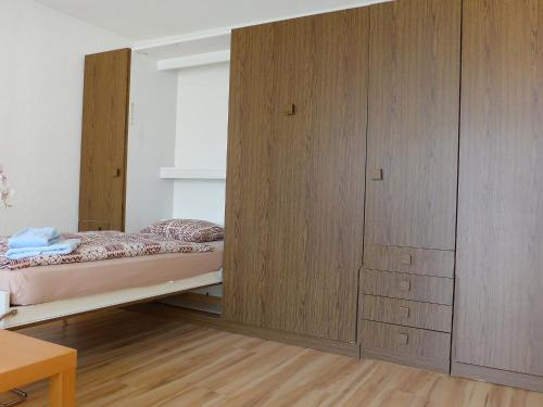 ツェルマットにあるApartment Imperial-5 by Interhomeのベッドルーム1室(ベッド1台付)、木製キャビネットが備わります。
