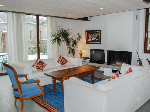 un soggiorno con divani bianchi e tavolo in legno di Apartment Cantagallo by Interhome a Vernate