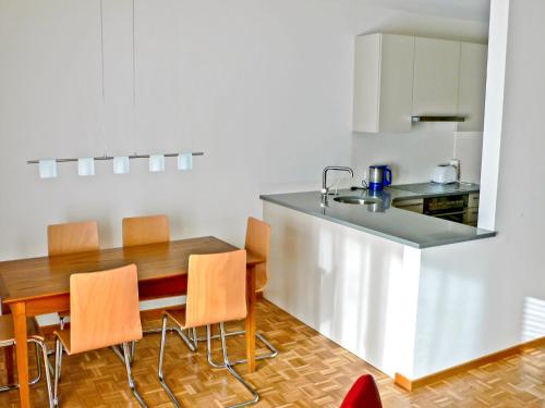 kuchnia z drewnianym stołem i krzesłami w pokoju w obiekcie Apartment Aldesago Monte Brè - Utoring-29 by Interhome w mieście Viganello