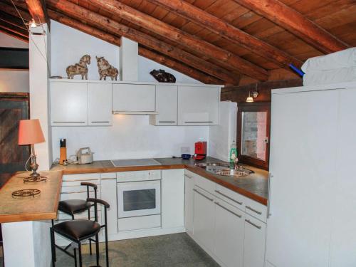 a kitchen with white cabinets and a table and chairs at Apartment Cantagallo by Interhome in Vernate