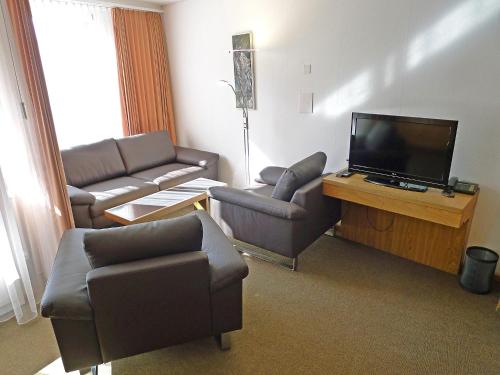 a living room with couches and a flat screen tv at Apartment Parkareal - Utoring-49 by Interhome in Davos