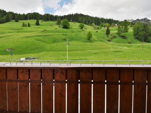 a fence with a green field and a hill at Apartment Penia 2-1 by Interhome in Penia