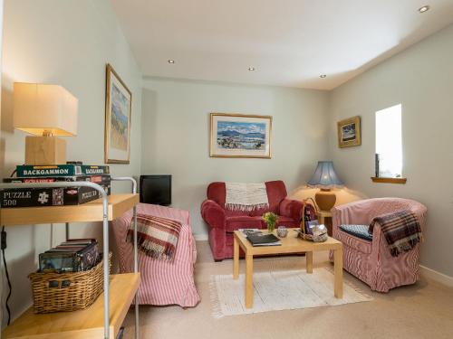 a living room with pink chairs and a table at Holiday Home Lorn Mill-2 by Interhome in Balloch