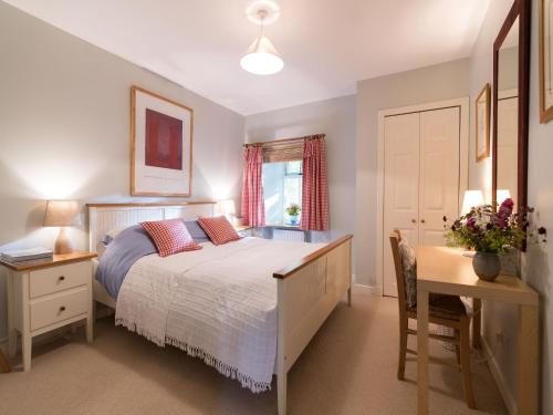 a bedroom with a bed and a table and a desk at Holiday Home Lorn Mill-2 by Interhome in Balloch