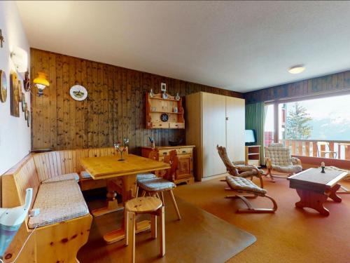 a living room with a wooden table and chairs at Studio Hameau A04 by Interhome in Les Collons