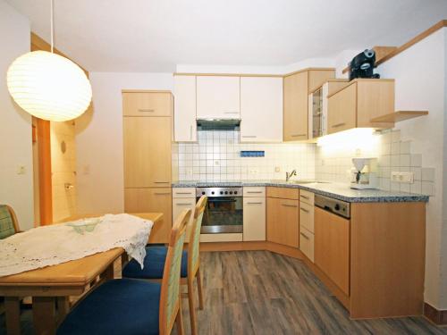 a kitchen with a table and a dining room at Apartment Camping Rossbach-1 by Interhome in Nassereith