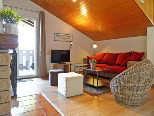 a living room with a red couch and a table at Apartment Les Bruyères 25 by Interhome in Chesières