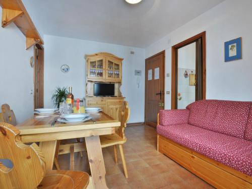 salon ze stołem i czerwoną kanapą w obiekcie Apartment Des Alpes-3 by Interhome w mieście Canazei