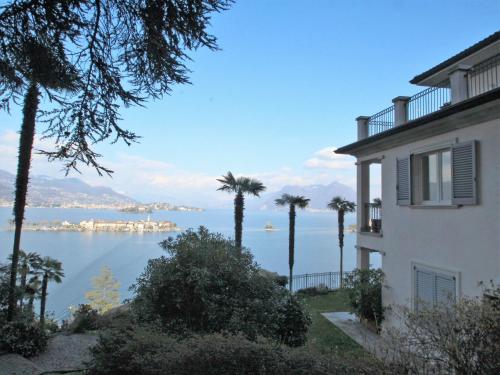 ein Gebäude mit Palmen und Blick auf das Wasser in der Unterkunft Apartment Punta Borromea by Interhome in Stresa