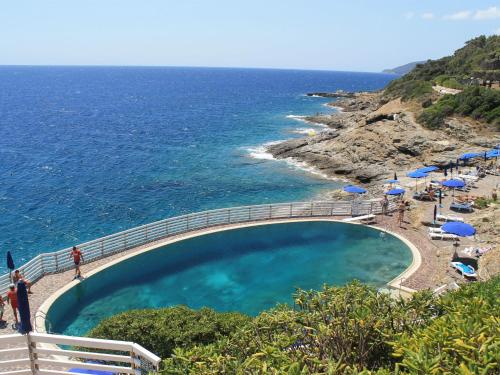 Capo D'ArcoにあるApartment Capo d'Arco-3 by Interhomeの海のそばの崖の上のスイミングプール