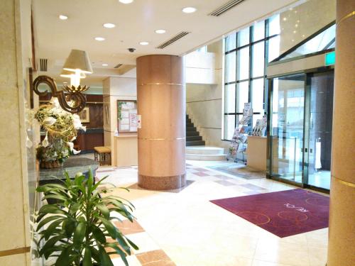 eine Lobby mit einer Pflanze in der Mitte eines Gebäudes in der Unterkunft Hotel Resol Sapporo Nakajima Koen in Sapporo