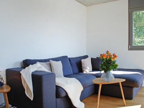 eine blaue Couch in einem Wohnzimmer mit einer Vase aus Blumen in der Unterkunft Apartment Allaventura by Interhome in Mergoscia