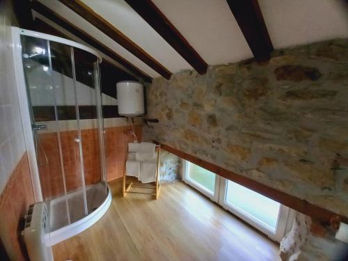 baño con ducha y pared de piedra. en Errotazar apartamento rural P, en Alsasua