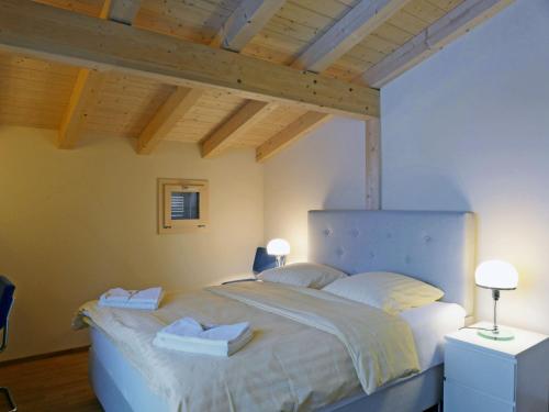 a bedroom with a bed with two towels on it at Apartment Bab Port Apt- 03 by Interhome in Wengen