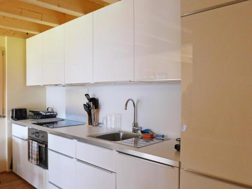 eine Küche mit weißen Schränken und einem Waschbecken in der Unterkunft Apartment Bab-Port by Interhome in Wengen
