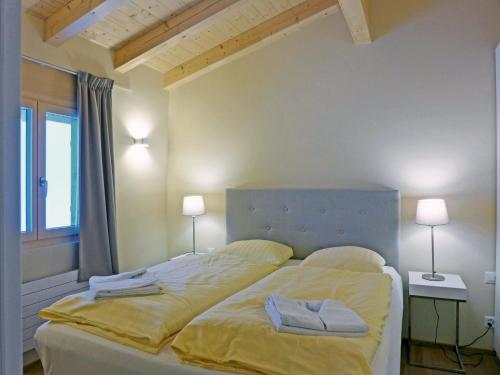 a bedroom with a large bed with two towels on it at Apartment Bab-Port by Interhome in Wengen