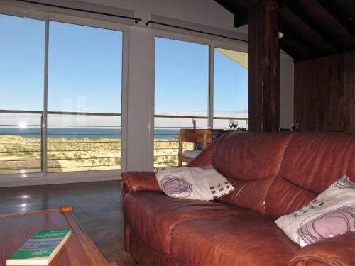 - un canapé en cuir dans le salon avec vue sur l'océan dans l'établissement Apartment Capama-2 by Interhome, à Mimizan-Plage