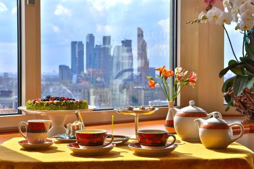 
a table topped with plates of food next to a window at Golden Ring Hotel in Moscow
