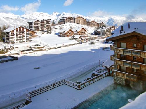 a resort in the snow with snow covered mountains at Apartment Le Refuge 1 by Interhome in Nendaz
