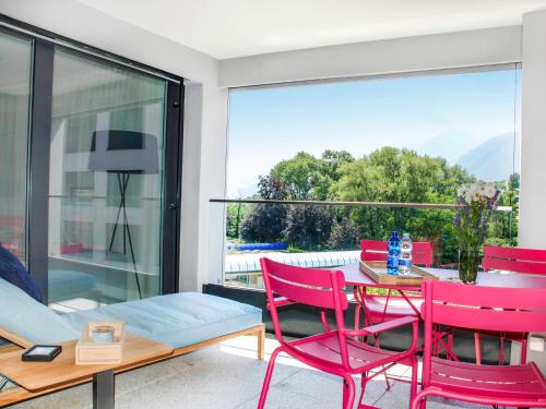 a living room with red chairs and a table at Apartment LaVille A-3-3 by Interhome in Locarno