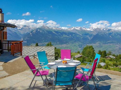 a table and chairs with a view of mountains at Chalet Le Ruisseau by Interhome in Nendaz