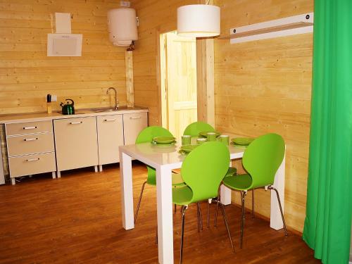 ミエレンコにあるHoliday Home Onyx-2 by Interhomeのキッチン(白いテーブル、緑の椅子付)