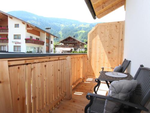 einen Balkon mit einem Tisch und Stühlen auf einer Holzterrasse in der Unterkunft Apartment Schweiberer-2 by Interhome in Aschau