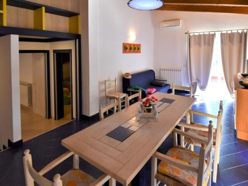 a dining room and living room with a table and chairs at Apartment Villa Isotta-3 by Interhome in Rosolina Mare