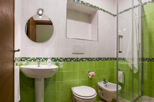 a green and white bathroom with a sink and a toilet at Back to Sorrento in Sant'Agnello