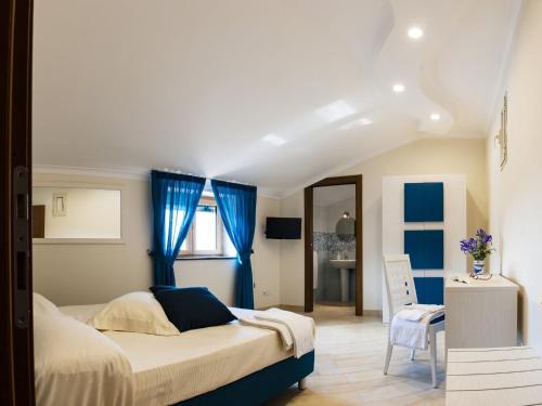 Schlafzimmer mit einem großen Bett und blauen Vorhängen in der Unterkunft Back to Sorrento in Sant'Agnello