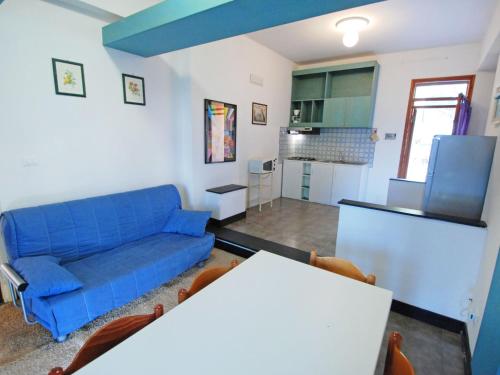 sala de estar con sofá azul y cocina en Apartment Villa Isotta-1 by Interhome, en Rosolina Mare