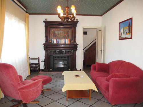 ミミザン・プラージュにあるHoliday Home Tourterelles by Interhomeのリビングルーム(赤い椅子2脚、暖炉付)
