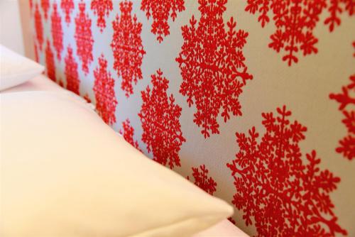a bed with a red pattern on a wall at Hotel Dr Otto Murr B&B in Sankt Anton am Arlberg