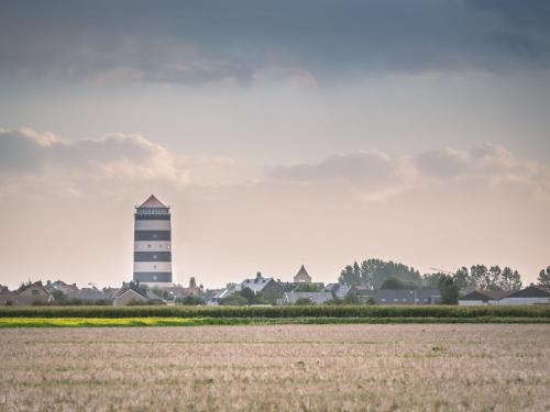 a water tower in the middle of a field at Apartment Cocoon by Interhome in Bredene
