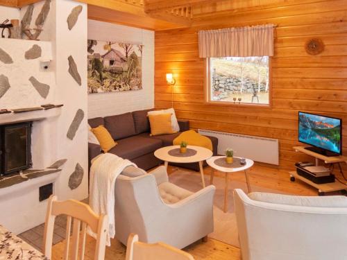 ein Wohnzimmer mit Sofa und Fernseher in der Unterkunft Holiday Home Pesäkolo by Interhome in Kiviperä