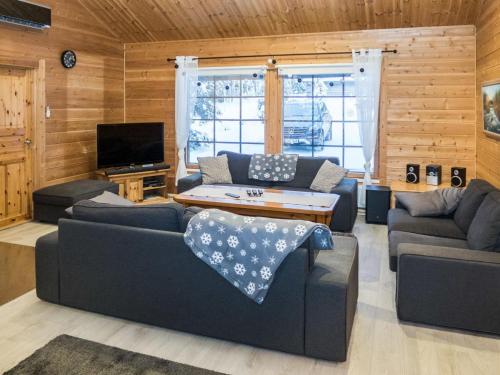 ein Wohnzimmer mit 2 Sofas und einem TV in der Unterkunft Holiday Home Huvihovi by Interhome in Ruka