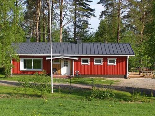 uma cabina vermelha com um telhado preto num campo em Holiday Home Ellilä by Interhome em Palonurmi